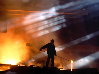 Smelting worker moving ore in landscape shot