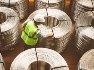 Male worker examining metal coils