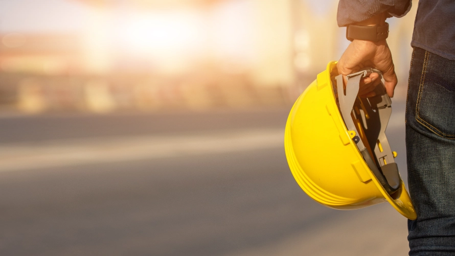 Construction worker holding safety helmet