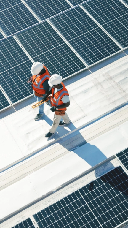 Two solar panel workers walking alongside panels