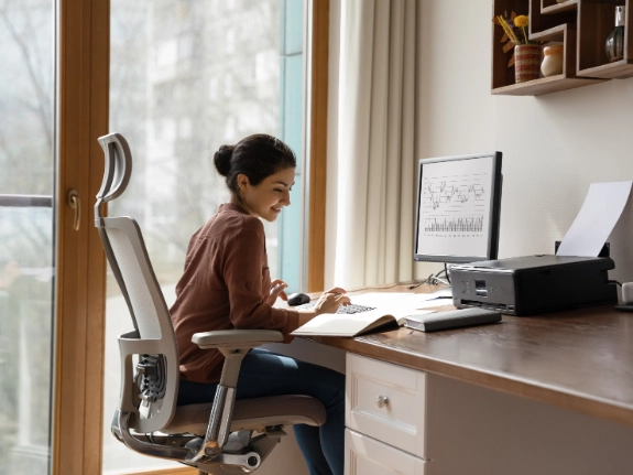 woman behind desk working on computer
