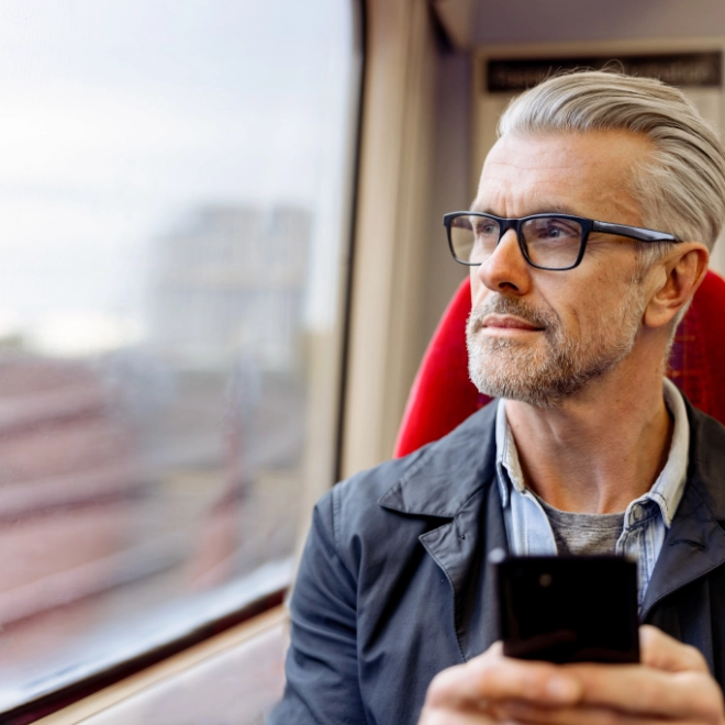man on a train holding a mobile phone